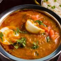Anda Curry · Boiled egg in yogurt, onion, and tomato sauce topped with chopped cilantro, onions, and toma...