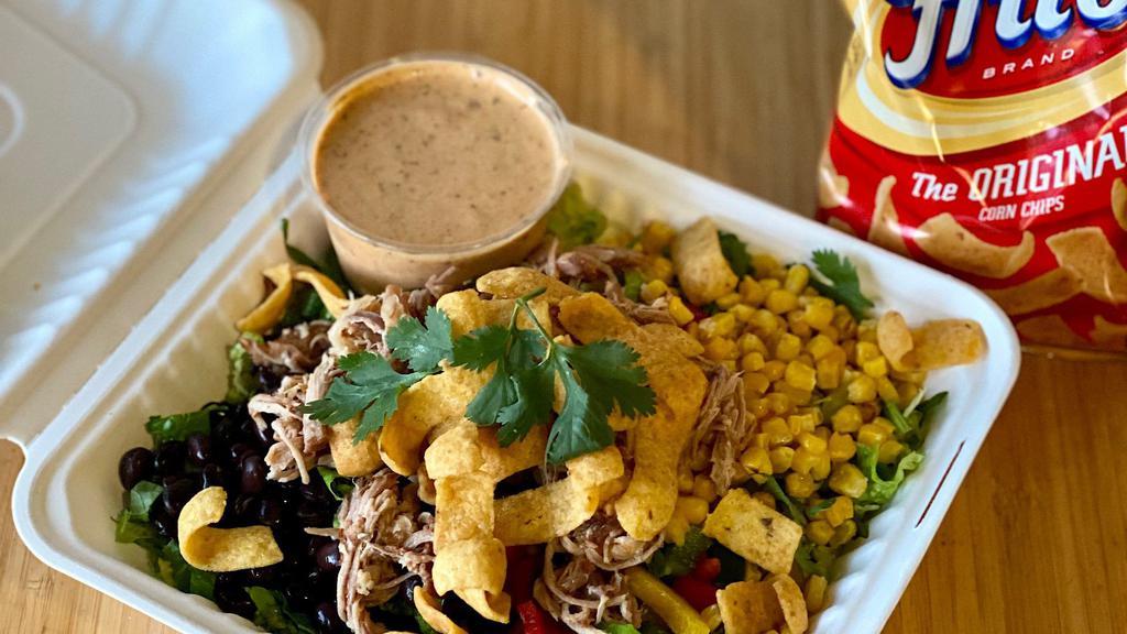 Pulled Pork Taco Salad · Romaine, Cubano Pulled Pork, Black Beans, Roasted Corn, Bell Pepper, Cilantro + Corn Chips with Chipotle Ranch.