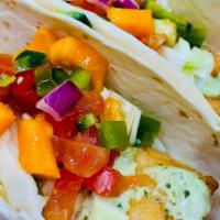 Fish Tacos · Two large tilapia filets, prepared blackened or fried. Topped with a cilantro lime crema, an...