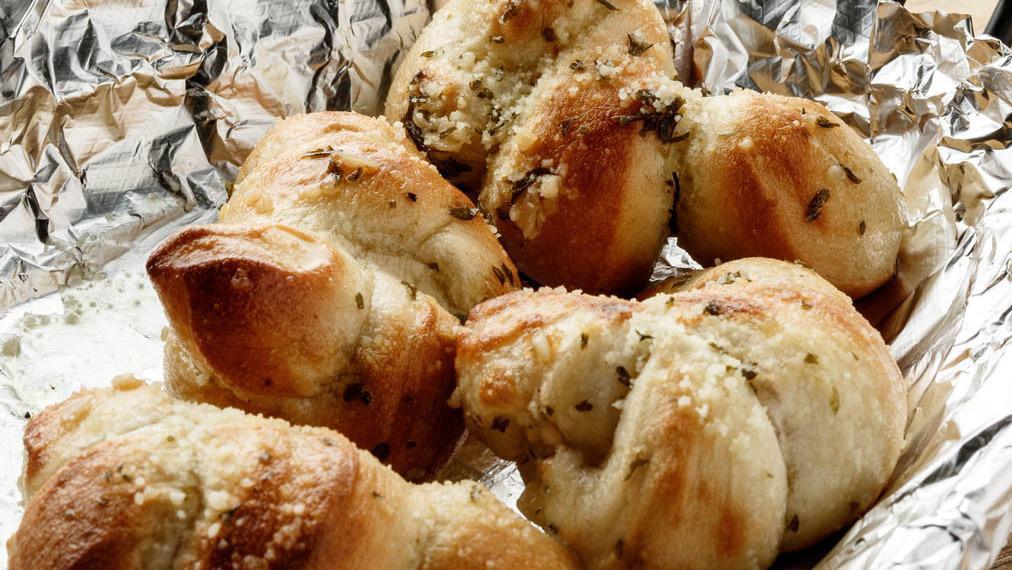 Garlic Knots (4) · Award winning pizza dough tied in a knot and baked to perfection, then tossed in EVOO, Fresh Garlic, Romano Cheese and Parsley.