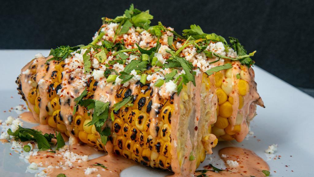 Mexican Street Corn · Grilled corn on the cob, drizzled sriracha mayo, queso fresco, cilantro, dusted with tajin.
(a must try)
