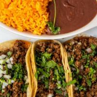 Taco Platter · Three soft corn tortilla tacos, topped with onions, cilantro, Mexican rice and refried beans...