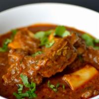 Goat Curry · Tender pieces of goat with bone cooked with herbs and spices in medium gravy. Mild to medium...