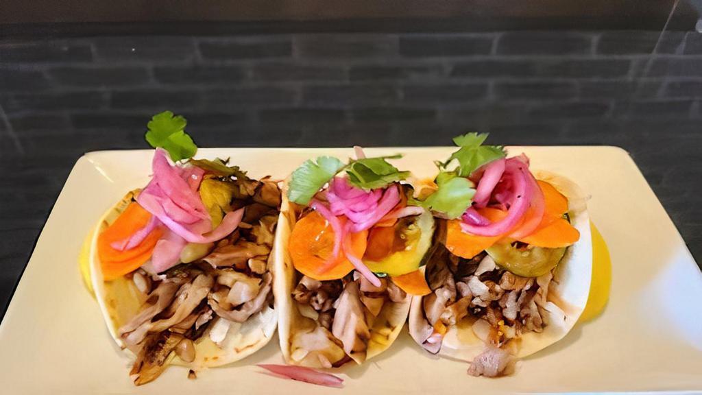 Korean Bbq Pork Tacos · Grilled pork marinated in Gochujang-rice vinegar & soy-ginger.  Served on flour tortillas with cabbage,  spicy cucumbers carrots & cilantro