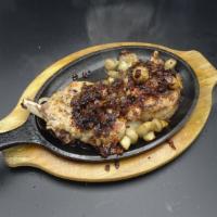 Grilled 16 Oz. French Cut Pork Chop · Served on a skillet with mushroom and onions.