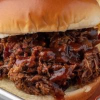 Beef Brisket Sandwich · Slow-Smoked Beef Brisket piled and topped with our BBQ sauce.  Served with potato chips