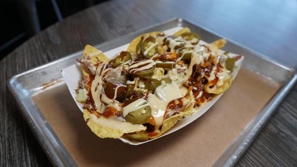 Bbq Nachos Small- Boat · Tortilla chips with your choice of BBQ meat topped with queso, onions, pickles, jalepenos and Backyard Red sauce.