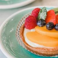 Tropical Tart  · Pâte sucrée filled with pastry cream and topped with fresh berries, peaches & kiwi.