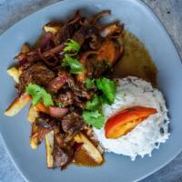 Lomo Saltado · Sautéed steak with tomatoes and onions, served over a bed of french fries with white rice.