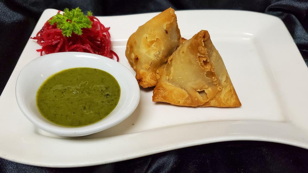 Vegetable Samosa · Triangular turnovers filled with potatoes, green peas, served with mint, tamarind chutney.