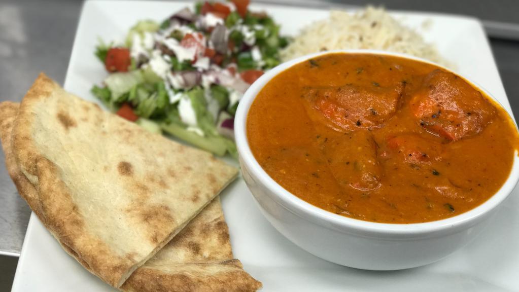 Chicken Tikka Masala Curry · Chicken breast tenders marinated in spice and yogurt, baked in a tandoor oven and cooked in a tomato based creamy sauce.served with salad, Kabuli rice and  naan bread.