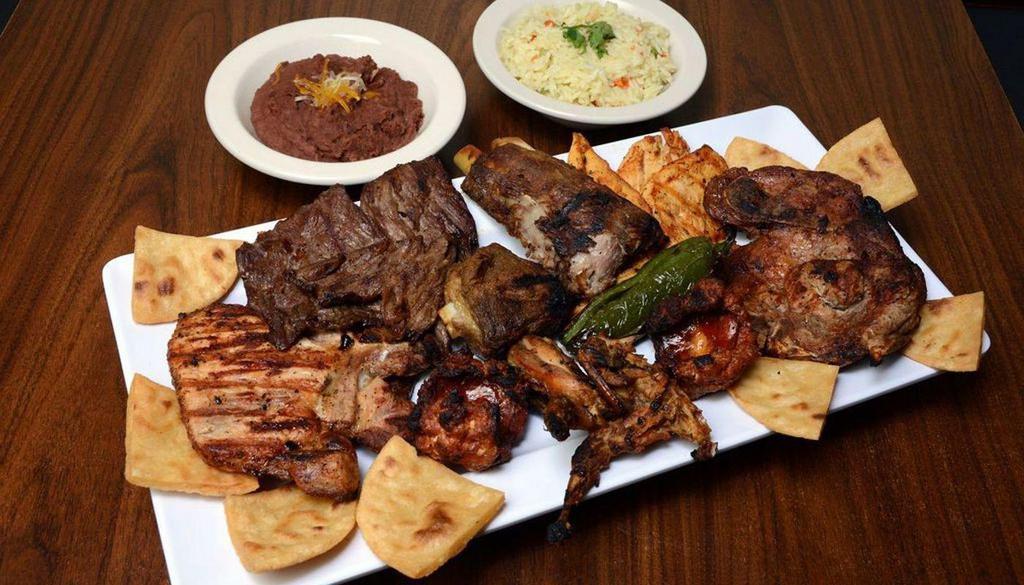 Parrillada Costa Real · Grilled beef sausage chicken breast pork chop pork ribs quail 2 jalapenos fried tortilla rice beans and french fries.
