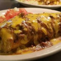 Texas Burrito · Homemade Flour Tortilla filled with Carne Guisada, Rice, Beans, and topped with Gravy and Ch...