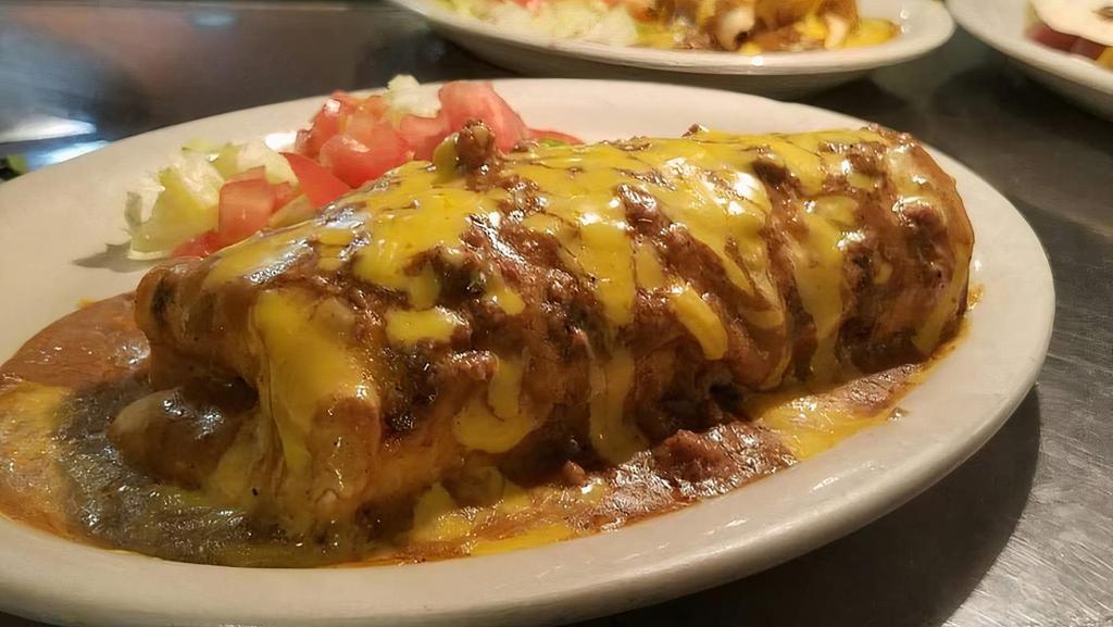 Texas Burrito · Homemade Flour Tortilla filled with Carne Guisada, Rice, Beans, and topped with Gravy and Cheese