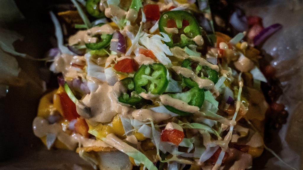 Nacho Fries · House fries served with nacho cheese, ground beef, chipotle aioli, diced tomato, shredded cabbage, and jalapeños. Vegan option available! Try our beyond burger blend.