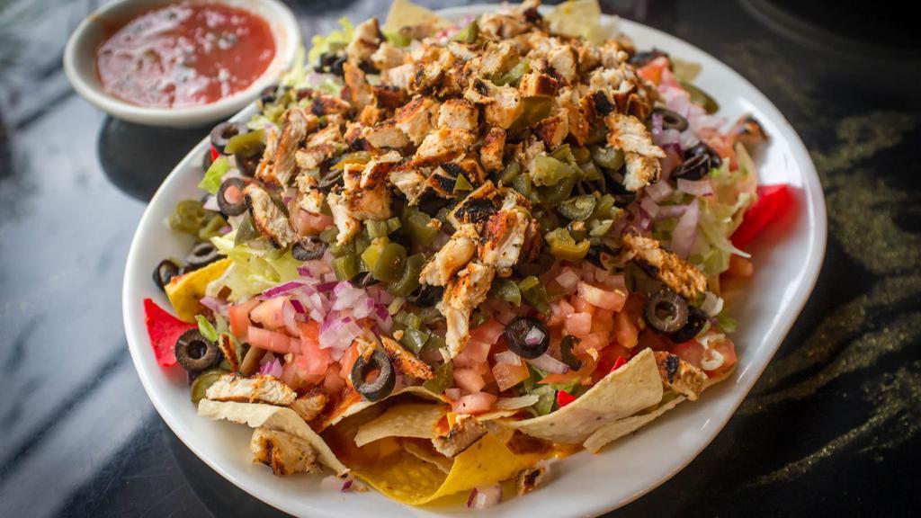 Chicken Nacho Supreme · Delicious bean and cheese nachos with your choice of shredded chicken and a side of guacamole, sour cream and jalapeños.