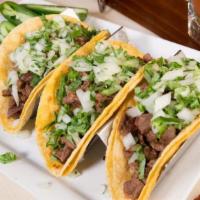 Chori Tacos · Chorizo and grilled onions on two flour tortillas topped with cheese. Served with rice and b...