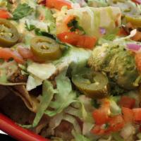 Border Nachos · Corn tortilla chips built high with re-fried beans, ground beef, espinaca dip, lettuce, guac...