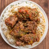 Oxtails · Tender fall off the bane oxtails over a bed of white rice and two sides.