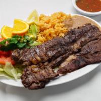 Carne Asada · Tender roast beef topped with onions. Served with rice, beans, lettuce, guacamole, pico de G...