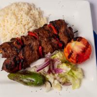 Adana Kebob (Gluten Free) · Skewer of beef and lamb marinated with peppers and onion served on flat bread, served with r...
