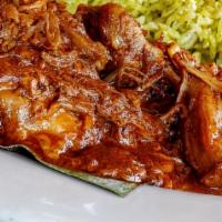 Cochinita Pibil · Achiote-marinated pork, braised in banana leaves. Served with poblano rice, pickled habanero...
