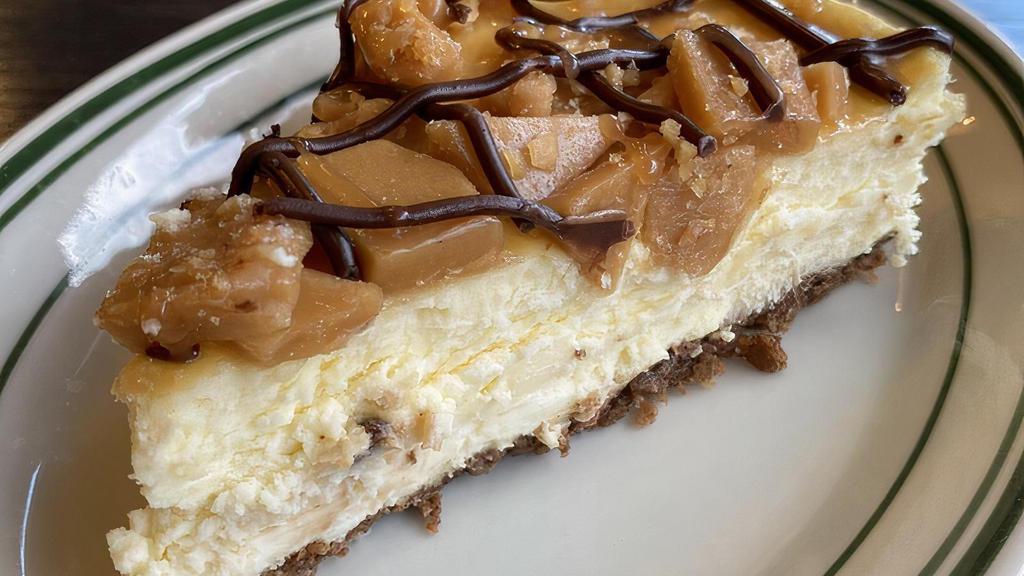 Toffee Crunch Cheesecake · A light and fluffy New York style cheesecake topped with pieces of toffee and drizzled with fudge and caramel.