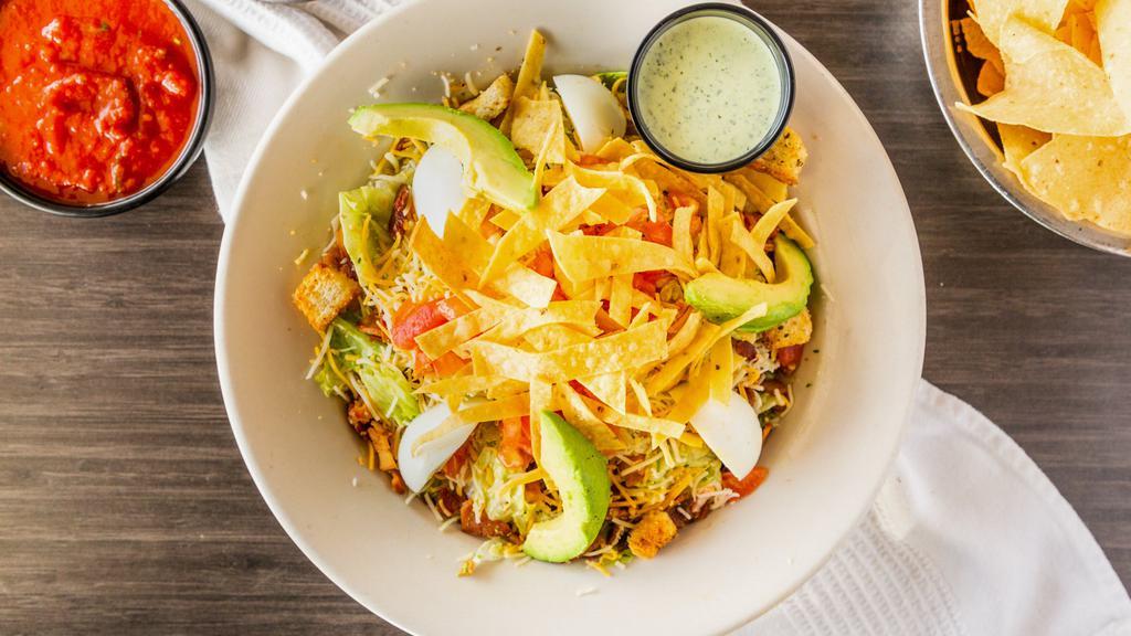 Avocado Chicken Salad · Grilled chicken, mixed lettuce, boiled eggs, bacon and diced tomatoes, mixed with avocado ranch dressing, Monterey cheddar cheese, croutons, sliced avocados and tortillas strips.