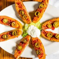 Potato Skins · Four potato halves filled with bacon, cheese and jalapeños, served with sour cream.