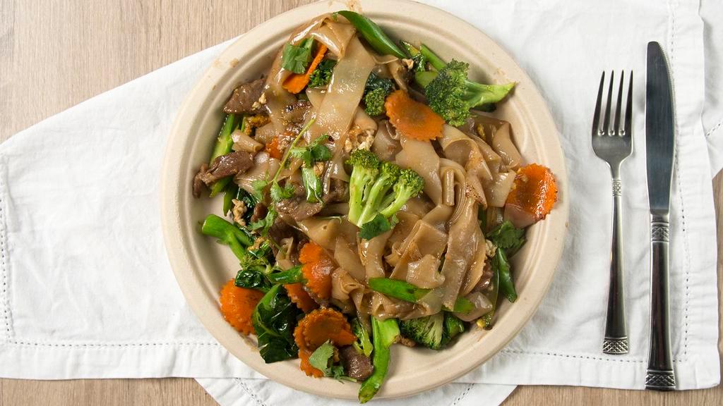 Pad See-Ew (Soy Sauce Noodles) · Flat rice noodles stir fried with house soy sauce, carrot, broccoli, Chinese broccoli, and egg.