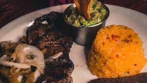 Tampiquena · Grilled skirt steak, served with cheese enchilada, guacamole, mexican rice, and refried beans. Garnished with onions and roasted poblano peppers.