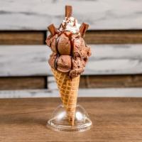 Kit Kat Krumble · Chocolate ice cream in a waffle cone drizzled with chocolate syrup and topped off with whip ...