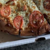 White Pizza · Cheddar, mozzarella, feta, garlic spread, sliced tomatoes and basil.
