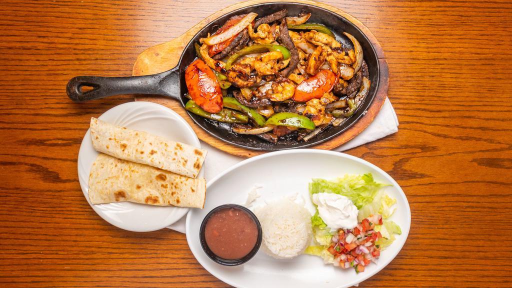 Fajitas · Our sizzling fajitas are served with Mexican rice, black beans, lettuce, pico De gallo, guacamole and flour tortillas.