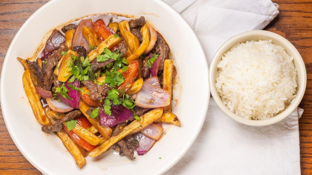 Lomo Saltado / Steak & Fries · Sliced steak sautéed in a tomato and onion sauce with French fries. Served with rice and beans.