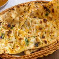Garlic Naan · Freshly baked flatbread with garlic smothered butter.