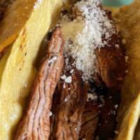 Short Rib Korean Tacos · 2 corn tortilla tacos filled with skirt steak, marinated in a soy sauce, ginger and topped w...