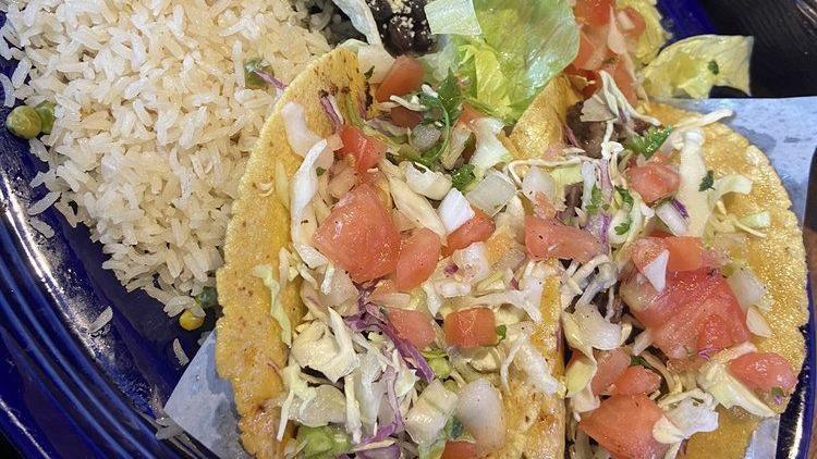 Mediterranean Tacos · Blackened tilapia topped with cabbage, roasted poblano peppers, tomatoes, green olive and caper salsa. Accompanied by white rice and black beans.