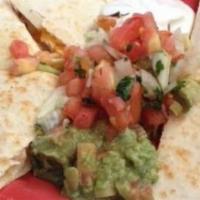 Traditional Quesadilla · Stuffed with Cheddar cheese and your choice of ground beef or chicken. Topped with tomatoes,...