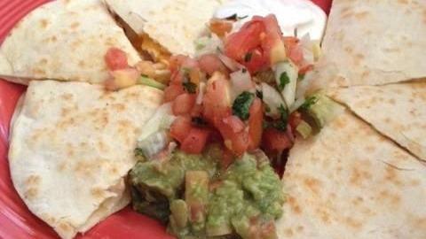 Traditional Quesadilla · Stuffed with Cheddar cheese and your choice of ground beef or chicken. Topped with tomatoes, onions, sour cream and guacamole.