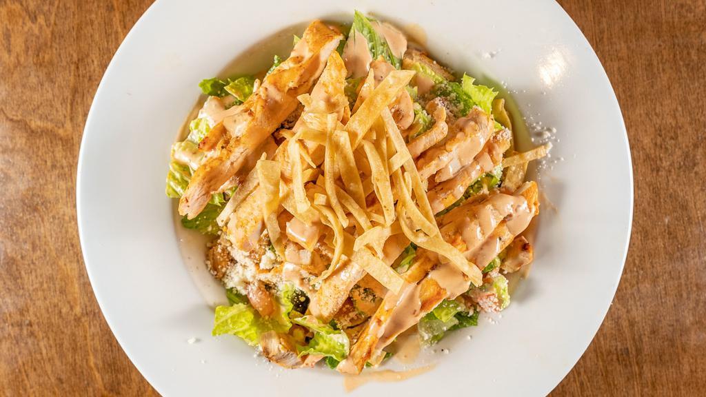 Southwestern Caesar Salad · A new spicy twist on the traditional Caesar Salad, with corn, tomatoes, Cotija cheese and grilled chicken or shrimp, black beans and tortilla chips tossed in chipotle-lime dressing.