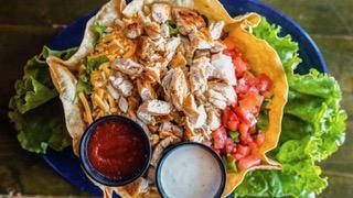 Taco Salad · Grilled seasoned chicken or beef in a large crispy tortilla shell, filled with pinto beans, salad greens, tomato, cheese and black olives. Served with sour cream and salsa.