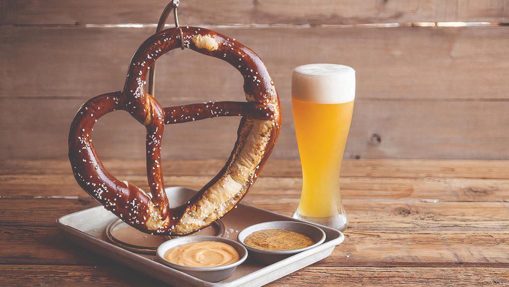 German Pretzel · A giant Bavarian pretzel as big as your head, baked soft on the inside, crispy on the outside & salted. served with house-made stone ground mustard.