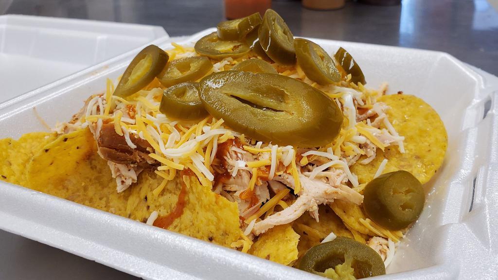 Chopped Brisket Nachos · Juicy, succulent brisket on top of a bed of tortilla chips. Topped with sour cream, shredded cheese, jalapenos, and your choice of sauce.