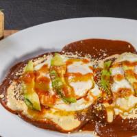 Pupusa Montañesa / Montañesa Pupusa · Dos pupusas cubiertas con frijoles, crema, dos huevos, queso, salsa verde o roja y aguacate....