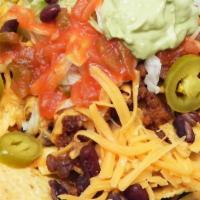 Nachos Supremos · Cheese nachos with ground beef, shredded chicken, beans, lettuce, tomatoes, sour cream and g...
