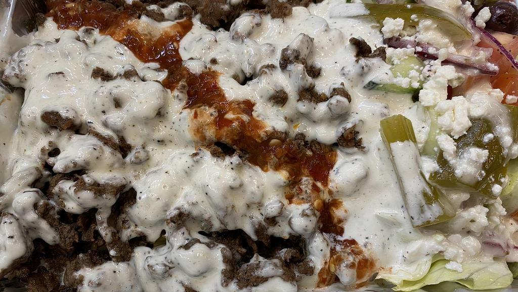 Beef Shawarma Plate · Beef shawarma, rice, lettuce, cucumber, tomato, onion, olive, pickled, feta cheese, dressing, hot sauce, and white sauce.