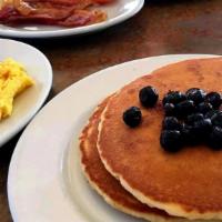 Blueberry Pancake Combo · Served with pancakes, two eggs, choice of ham, bacon (4) or link sausage (4).