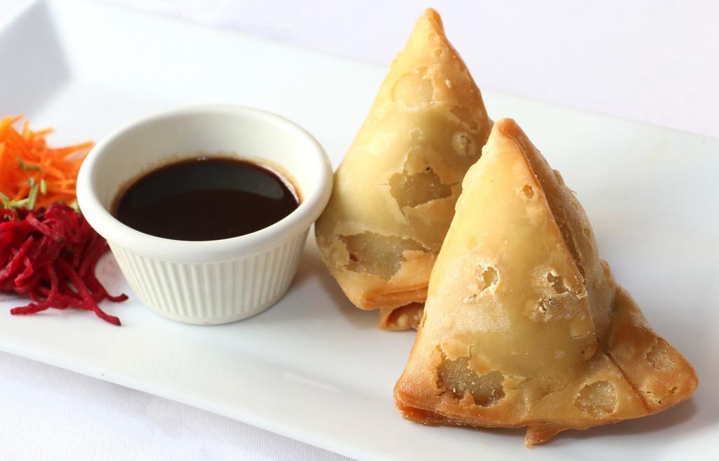 Vegetable Samosa · Vegan. Pastry shells stuffed with spiced potato and peas, served with tamarind chutney.