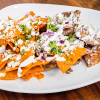 Pan & Coffee Chilaquiles · Fried tortilla chips and tossed in a tomato and black bean salsa, drizzled with Mexican crea...